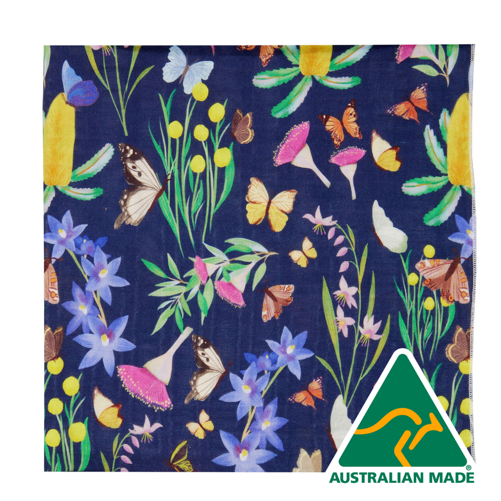 Festive fabric with colorful flowers and butterflies on a blue background, featuring 'Australian Made' logo.