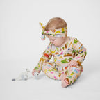 Baby girl wearing Aussie Road Trip organic cotton outfit with matching knot headband sitting beside wooden kangaroo toys