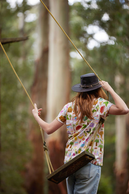 Model on rope swing wearing Aussie Road Trip organic cotton Australian inspired t-shirt in bush setting.