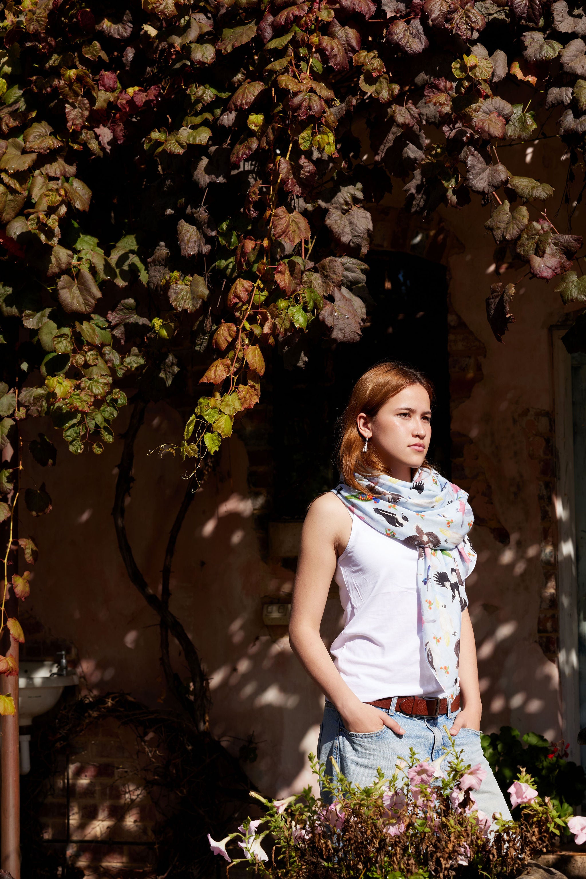 Fashion lifestyle image of a woman styling a lightweight Australian bird print scarf with casual denim.