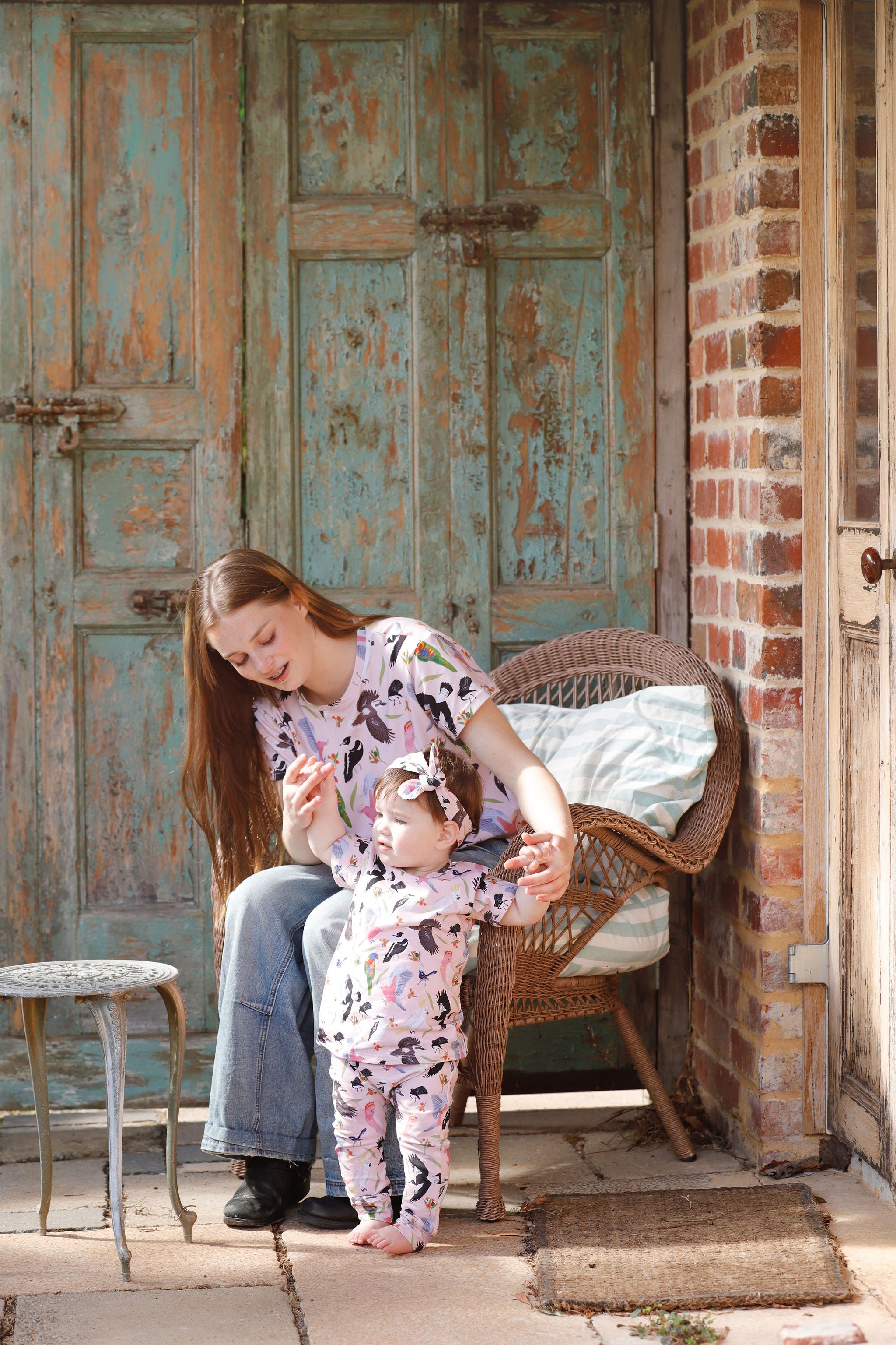Toddler wearing Backyard Birds baby pants and matching top with mother outdoors in rustic Australian setting