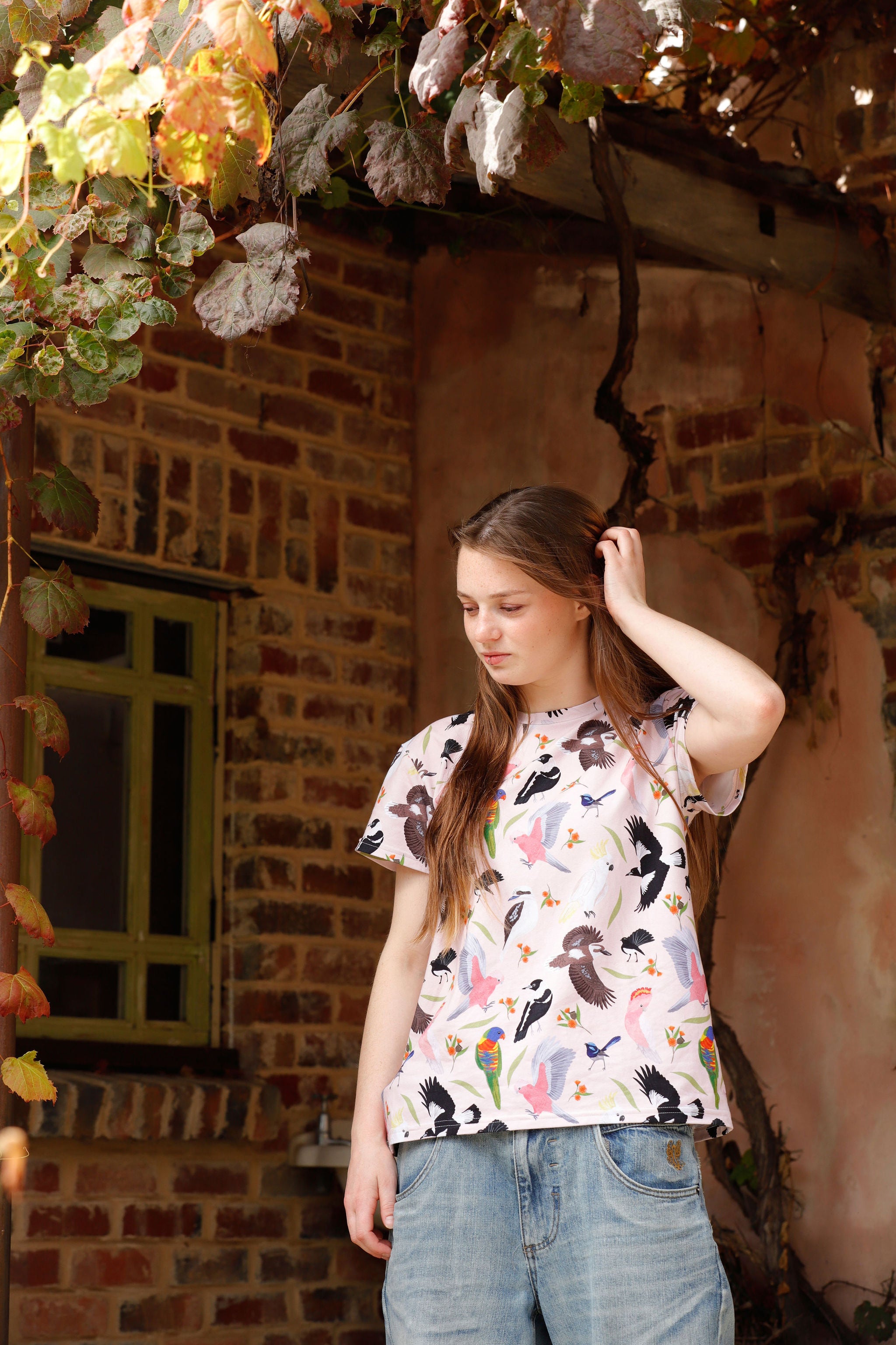 Girl wearing the Backyard Birds peach Australian native bird print t-shirt illustrated by Christie Williams