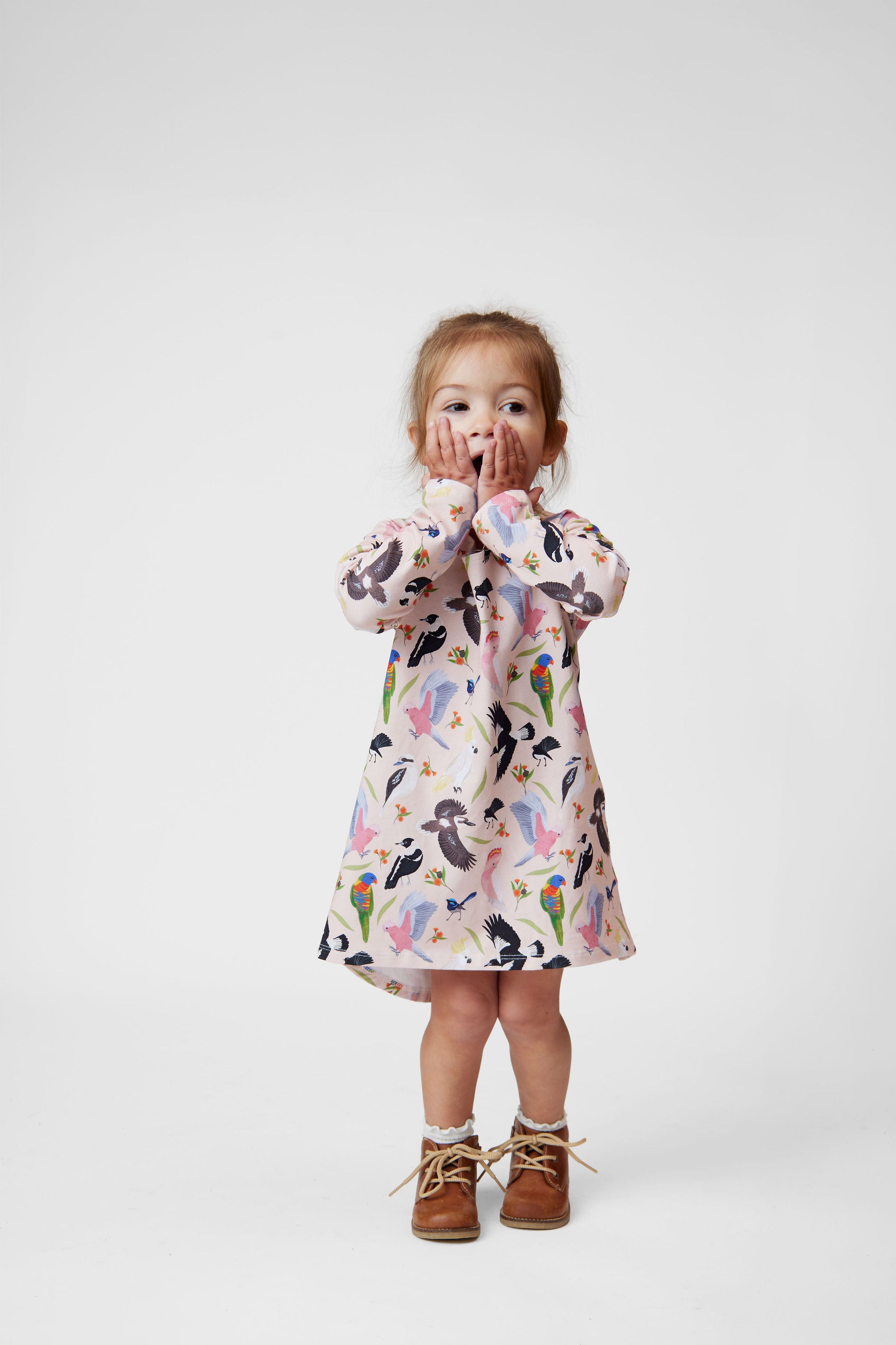 Toddler girl wearing pink Australian bird print long sleeve dress by Pebble and Poppet