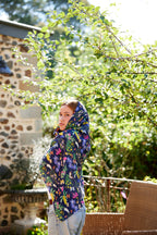 Young woman wearing the Butterfly Flora bamboo scarf by Christie Williams styled as a soft hooded headscarf outdoors