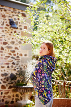 Young woman wrapped in the Butterfly Flora bamboo scarf featuring Australian florals and butterflies on a navy background