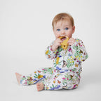 Baby wearing Australian made Butterfly Flora organic cotton pants and top while holding a teether in a studio setting.