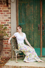 Woman wearing the Butterfly Flora White bamboo scarf styled as an elegant flowing sarong outdoors
