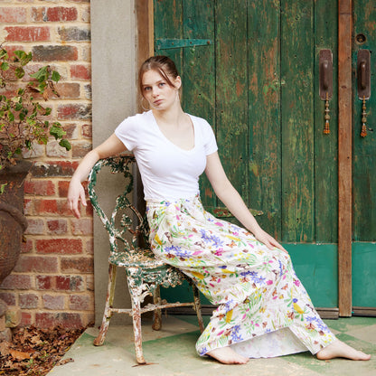 Woman wearing the Butterfly Flora White bamboo scarf styled as an elegant flowing sarong outdoors