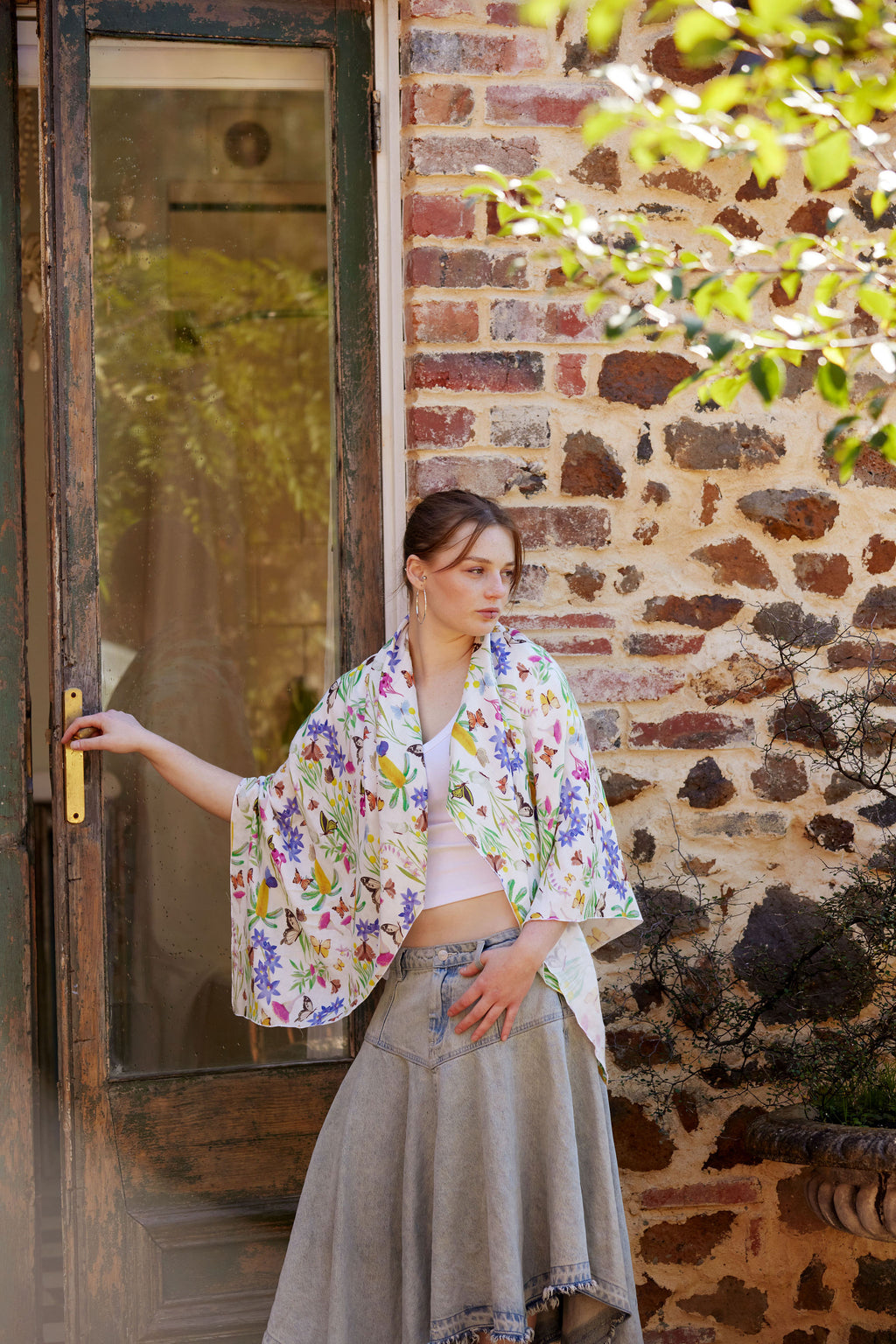 Young woman wearing the Butterfly Flora White bamboo scarf by Christie Williams featuring butterflies and Australian florals
