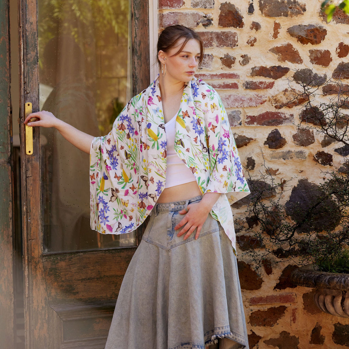 Young woman wearing the Butterfly Flora White bamboo scarf by Christie Williams featuring butterflies and Australian florals