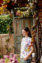 Portrait of model wearing Butterfly Flora White floral butterfly print t-shirt in vintage doorway.