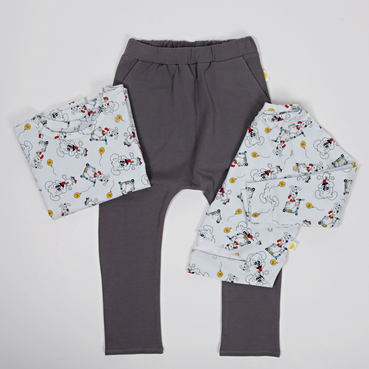 Kids organic cotton puppy print long sleeve top paired with soft grey pants in a flat lay outfit set