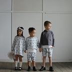 Three children wearing organic cotton puppy print outfits from an Australian kids clothing collection
