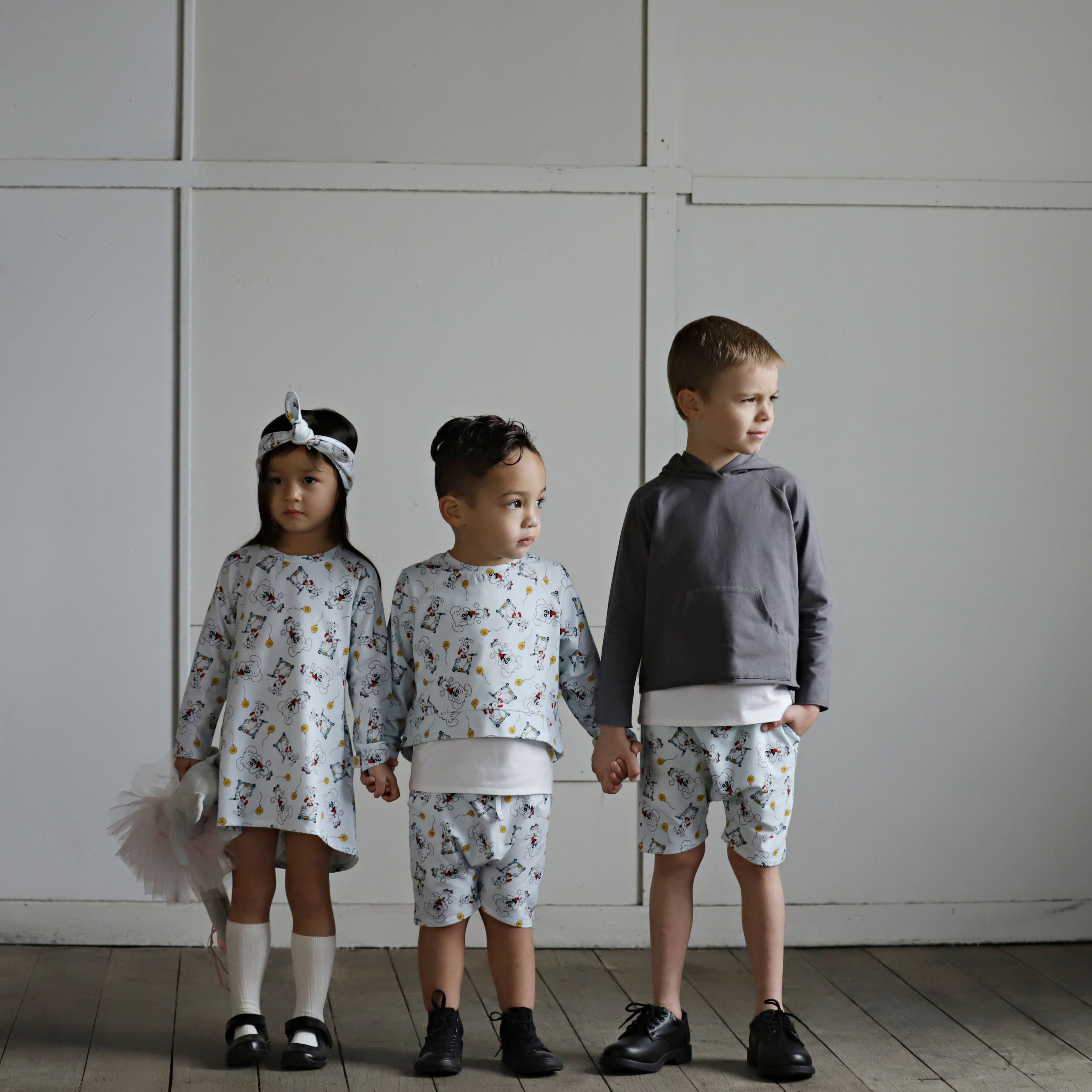 Three children wearing organic cotton puppy print outfits from an Australian kids clothing collection