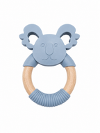 A koala-shaped baby teething ring with a light blue silicone head and natural wood ring, featuring a ribbed blue silicone chew section at the bottom, shown on a plain white background.