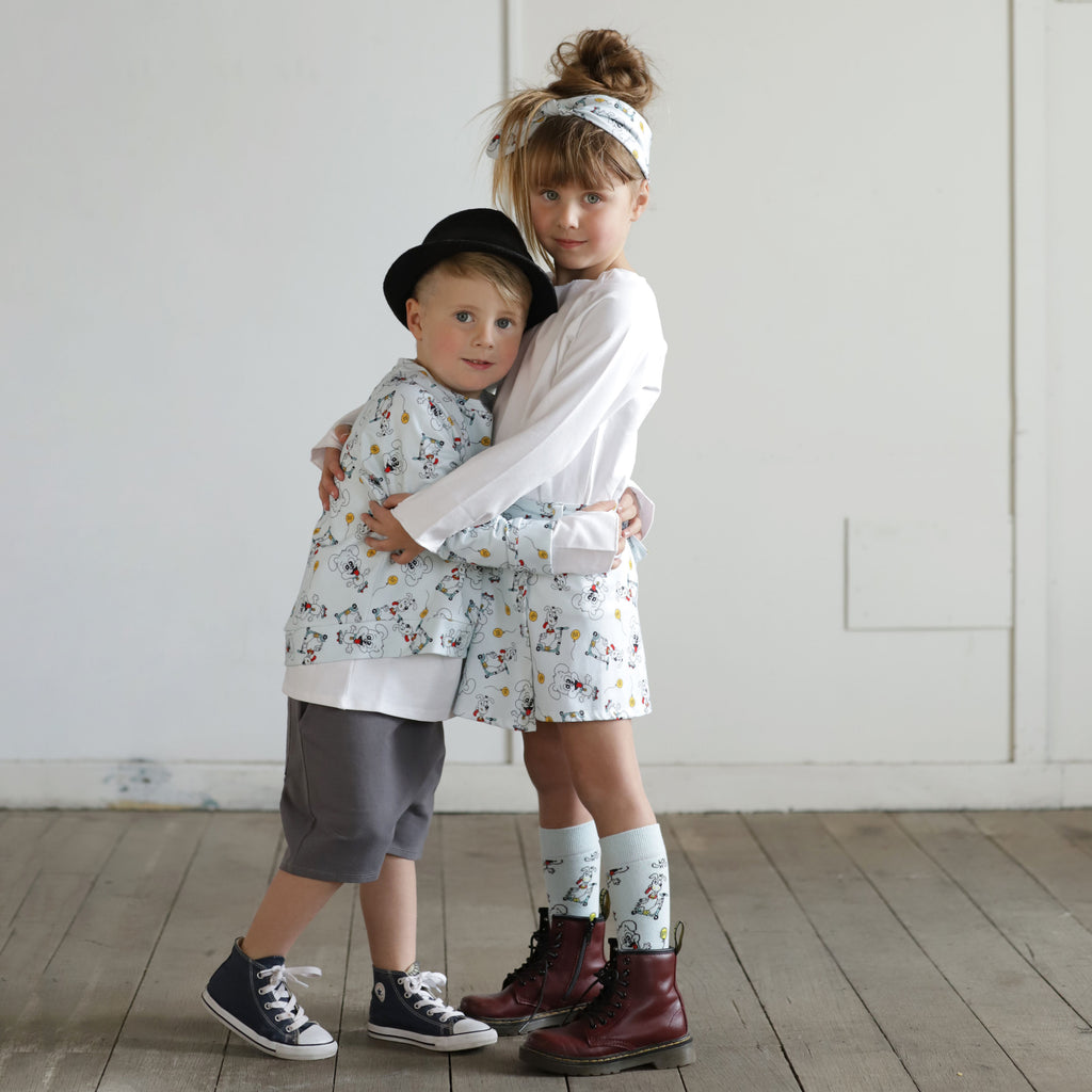 Brother and sister wearing matching puppy print organic cotton outfits