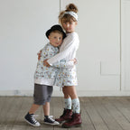 Brother and sister wearing matching puppy print organic cotton outfits