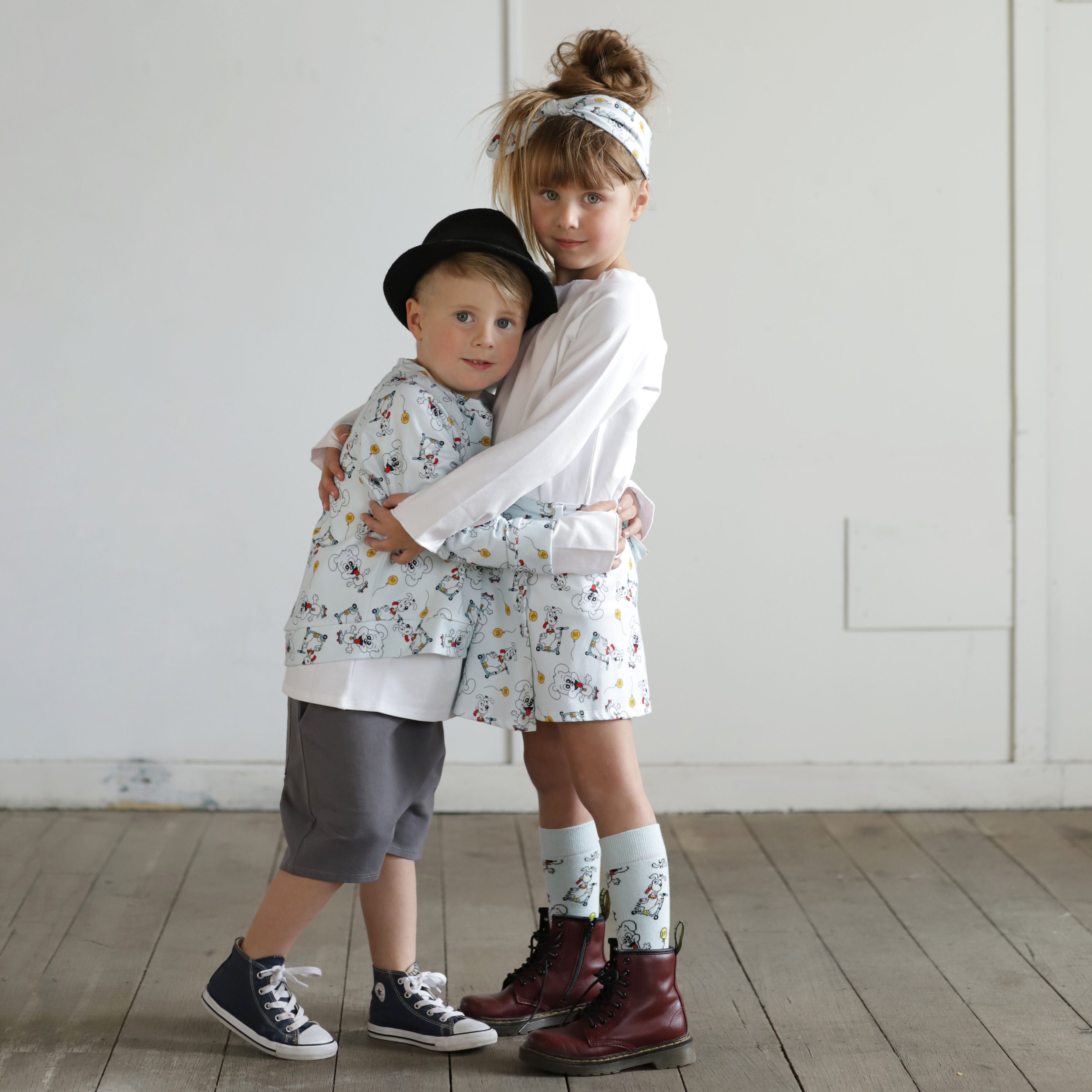 Brother and sister wearing matching puppy print organic cotton outfits