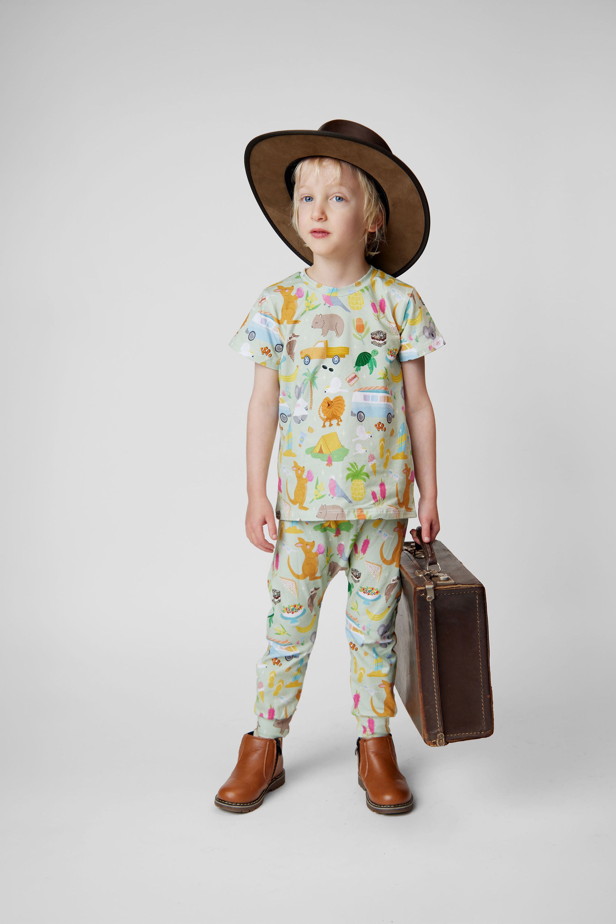 Australian inspired kids travel outfit featuring Summer Down Under organic cotton t-shirt and pants with whimsical Australian print including kangaroos, caravans and camping icons. Designed and made in Australia.